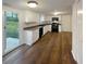 Well-lit kitchen with white cabinetry, black appliances, and hardwood flooring at 4396 Shelley Nw Ln, Lilburn, GA 30047