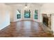 Bright living room with fireplace, large windows, hardwood floors and a ceiling fan at 4396 Shelley Nw Ln, Lilburn, GA 30047