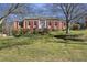 Charming brick home with red shutters and a well-manicured front yard featuring mature landscaping at 663 Foxcroft Circle Se, Marietta, GA 30067
