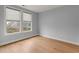 An empty bedroom featuring hardwood floors, baseboard trim, and two bright windows with shades at 901 Abernathy Ne Rd # 3220, Sandy Springs, GA 30328