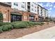 Commercial spaces on the ground floor with awnings, landscaping, and brick facade beneath apartments at 901 Abernathy Ne Rd, Sandy Springs, GA 30328