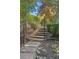 Landscaped backyard with a wooden staircase with wrought iron railing winding through lush greenery at 2480 Flint Creek Dr, Cumming, GA 30041