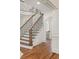 Elegant staircase with hardwood floors and wrought iron railing, showcasing the home's architectural details at 2480 Flint Creek Dr, Cumming, GA 30041