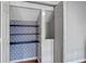 A closet featuring multiple shelves with blue and white patterned wallpaper at 2607 Westchester Se Pkwy, Conyers, GA 30013