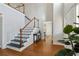 Bright foyer with hardwood floors, a staircase with white railings, and view to dining room at 2607 Westchester Se Pkwy, Conyers, GA 30013