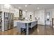 Bright kitchen featuring a large island with seating, stainless steel appliances, white cabinetry, and hardwood flooring at 347 Bailey Walk, Alpharetta, GA 30009