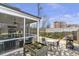 The backyard patio with stone border features a screened-in porch, seating, and planting box at 347 Bailey Walk, Alpharetta, GA 30009