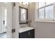 Powder room with a dark vanity, mirror, and window at 347 Bailey Walk, Alpharetta, GA 30009