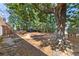 Large, landscaped backyard featuring a wooden deck, mature trees, and playhouse at 436 Carolwood Ln, Atlanta, GA 30342