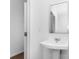 Clean bathroom with pedestal sink, white fixtures, and wood-look floors at 1744 Fawlocke Run, Loganville, GA 30052