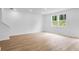Bright living room featuring hardwood floors and large windows offering natural light at 1744 Fawlocke Run, Loganville, GA 30052