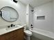 Modern bathroom featuring a round mirror, and a tub-shower with white subway tile surround at 3113 Bellgreen Way, Decatur, GA 30032