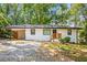 Inviting single-story house with a carport, freshly painted white exterior, and green surroundings at 3113 Bellgreen Way, Decatur, GA 30032