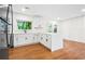 Modern kitchen with white cabinets, an island, hardwood floors, stainless steel appliances, and backyard views at 3113 Bellgreen Way, Decatur, GA 30032