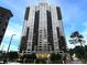 Exterior view of a modern high-rise condo building featuring balconies, trees, and manicured landscaping at 3481 Lakeside Ne Dr # 1705, Atlanta, GA 30326