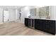 Modern basement bar area with a wine fridge, sink, and sleek black cabinetry at 904 Kings Ne Ct, Atlanta, GA 30306