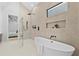 Bright bathroom featuring soaking tub, glass shower, and large format patterned tile at 904 Kings Ne Ct, Atlanta, GA 30306
