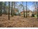 Large, leaf-covered backyard surrounded by mature trees, enhancing privacy and nature views at 1605 Loblolly Ln, Cumming, GA 30041