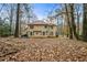 Wide shot of a leaf-strewn backyard surrounded by trees, offering privacy and a natural setting at 1605 Loblolly Ln, Cumming, GA 30041