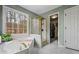 Bright bathroom features a soaking tub, shower and a door leading to a walk-in closet at 1605 Loblolly Ln, Cumming, GA 30041