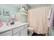 Well-lit bathroom with functional vanity, toilet, and shower with beige curtain at 1605 Loblolly Ln, Cumming, GA 30041