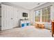 Bright bedroom with natural light from large windows, a TV, and storage shelves at 1605 Loblolly Ln, Cumming, GA 30041