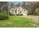 Charming tan two-story home featuring a manicured lawn and attached two car garage at 1605 Loblolly Ln, Cumming, GA 30041