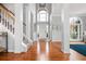 Bright foyer featuring hardwood floors, a staircase, and tall windows at 1605 Loblolly Ln, Cumming, GA 30041