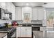 This well-lit kitchen features modern appliances, granite countertops, and white cabinets providing ample storage at 1605 Loblolly Ln, Cumming, GA 30041