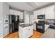 Well-equipped kitchen featuring white cabinets, black appliances and central island at 1605 Loblolly Ln, Cumming, GA 30041