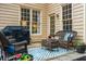 Cozy patio with wicker furniture, a grill, and a blue and white patterned rug at 1605 Loblolly Ln, Cumming, GA 30041