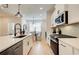 Modern kitchen featuring stainless steel appliances, a breakfast bar, and an adjacent dining area at 3352 Cranston Ln, Kennesaw, GA 30144