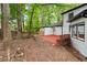 View of the backyard including a wood deck, mature trees and landscaping, and white siding on the home at 3900 Millwood Lane Nw, Lilburn, GA 30047