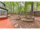A beautiful wooded backyard is surrounded by greenery with a deck and an elevated stone garden at 3900 Millwood Lane Nw, Lilburn, GA 30047