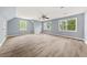 A spacious bedroom with light wood floors, a ceiling fan, and natural light from multiple windows at 3900 Millwood Lane Nw, Lilburn, GA 30047