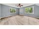 Bright bedroom featuring hardwood floors, a ceiling fan, and large windows with a peaceful view at 3900 Millwood Lane Nw, Lilburn, GA 30047