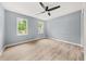 A clean bedroom with light wood floors, freshly painted light blue walls, and bright natural light at 3900 Millwood Lane Nw, Lilburn, GA 30047