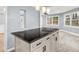 Kitchen island with a black countertop, white cabinets, and modern pendant lighting in an open space at 3900 Millwood Lane Nw, Lilburn, GA 30047