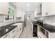 Bright kitchen features white cabinets, stainless appliances, black counters, and a farmhouse sink at 3900 Millwood Lane Nw, Lilburn, GA 30047