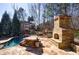 Inviting stone outdoor fireplace and seating area next to pool offers a relaxing outdoor space at 4978 Millwood Dr, Canton, GA 30114