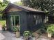 Stylish outbuilding, featuring dark siding, green doors and potted plants at 1954 Oak Grove Ne Rd, Atlanta, GA 30345