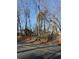 View of the tree-lined street and a peek of the home behind some trees at 1954 Oak Grove Ne Rd, Atlanta, GA 30345