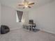 Cozy bedroom with carpeted floor, window, ceiling fan, desk and comfortable chair at 325 Caledonia Ct, Peachtree City, GA 30269