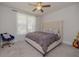 Stylish bedroom with a tufted headboard bed, a blue chair and a window with sheer curtains for soft, natural light at 325 Caledonia Ct, Peachtree City, GA 30269