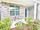 Inviting front porch featuring brick facade and seating area with two chairs and side table at 325 Caledonia Ct, Peachtree City, GA 30269