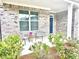 Charming front porch featuring decorative chairs, plants and brick and column accents at 325 Caledonia Ct, Peachtree City, GA 30269