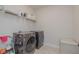 Practical laundry room with modern washer and dryer and shelving for storage at 325 Caledonia Ct, Peachtree City, GA 30269