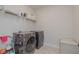 Functional laundry room with modern washer and dryer units and storage shelves at 325 Caledonia Ct, Peachtree City, GA 30269