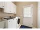 Practical laundry room with modern washer and dryer, cabinets and utility sink at 5970 Mallet Ct, Cumming, GA 30040