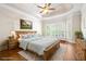 Cozy bedroom with a wooden bed frame, tray ceiling, and large windows for natural light at 5970 Mallet Ct, Cumming, GA 30040